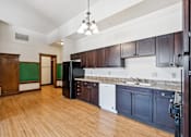 Thumbnail 9 of 17 - A kitchen with dark wood cabinets and a white dishwasher.