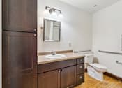 Thumbnail 15 of 17 - A bathroom with a sink, toilet, and mirror.