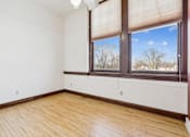 Thumbnail 14 of 17 - A room with a window and wooden flooring.