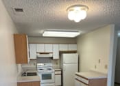 Thumbnail 5 of 13 - A kitchen with white appliances and wooden cabinets.