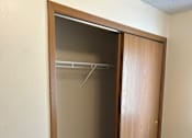Thumbnail 11 of 13 - A wooden closet with a shelf and a door is open.