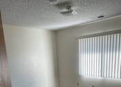 Thumbnail 7 of 13 - A room with a carpeted floor and a door on the left.