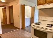 Thumbnail 6 of 15 - A white stove in a kitchen with a white oven.