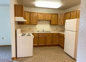 Thumbnail 5 of 15 - A kitchen with white appliances and wooden cabinets.