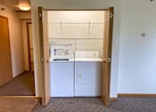 Thumbnail 14 of 15 - A small white fridge and dishwasher are in a small room.