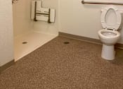 Thumbnail 10 of 15 - A white toilet in a small bathroom with a towel rack and a towel hanging on the towel rack.