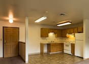 Thumbnail 5 of 10 - A kitchen with white appliances and wooden cabinets.