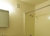 Thumbnail 9 of 10 - A bathroom with a sink, mirror, and bathtub.