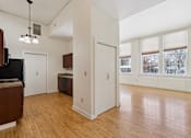 Thumbnail 12 of 27 - A kitchen with wooden floors and white walls.