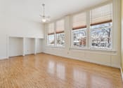 Thumbnail 11 of 27 - Empty room with wooden floors and white walls.