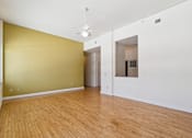 Thumbnail 5 of 27 - A room with a wooden floor and a ceiling fan.