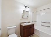 Thumbnail 10 of 27 - A white toilet sits next to a sink in a small bathroom.