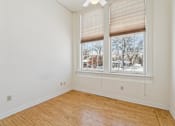 Thumbnail 9 of 27 - A room with a large window and wooden flooring.