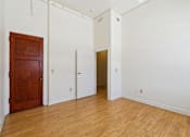 Thumbnail 6 of 27 - A room with a wooden door and two other doors.