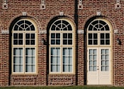 Thumbnail 18 of 27 - A red brick building with two arched windows and a door.