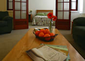 Thumbnail 14 of 27 - A table with a bowl of oranges and a book on it.