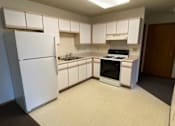 Thumbnail 2 of 6 - A kitchen with white appliances and white cabinets.
