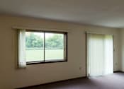 Thumbnail 6 of 12 - A room with a large window and a closed door.