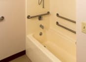 Thumbnail 10 of 12 - A white bathtub with a shower head and hand held shower.