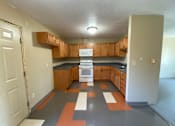 Thumbnail 4 of 13 - A kitchen with wooden cabinets and a black countertop.