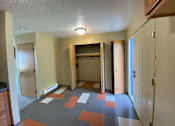 Thumbnail 7 of 13 - A hallway with a patterned floor and white walls.