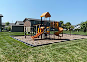 Thumbnail 13 of 13 - A playground with a yellow slide and a brown structure.