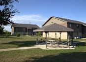 Thumbnail 1 of 13 - A large building with a covered patio in front.