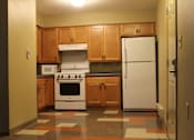 Thumbnail 5 of 13 - A kitchen with a white fridge, white stove and white microwave.