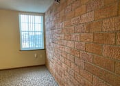 Thumbnail 10 of 17 - A room with a brick wall and a window.