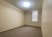 Thumbnail 11 of 17 - A room with a carpeted floor and a window with blinds.
