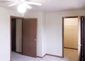 Thumbnail 8 of 12 - A room with a ceiling fan and two doors.