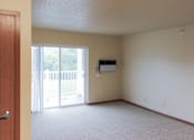 Thumbnail 5 of 12 - A room with a sliding glass door leading to a balcony.