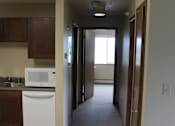 Thumbnail 6 of 12 - A small kitchen with a microwave, oven, and sink.