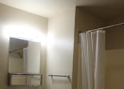 Thumbnail 10 of 12 - A bathroom with a sink, mirror, and shower.