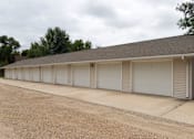 Thumbnail 6 of 6 - A long building with a grey roof and white garage doors.