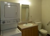 Thumbnail 5 of 6 - A bathroom with a toilet, sink, and a stove.