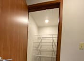 Thumbnail 8 of 12 - A hallway with a wooden door and a white wall.