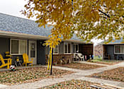 Thumbnail 2 of 12 - A yellow chair is in front of a house.