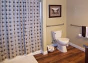 Thumbnail 10 of 11 - A bathroom with a toilet, a shower curtain, and a picture on the wall.