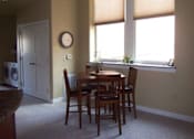 Thumbnail 8 of 11 - A dining room with a table and chairs.