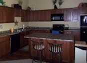 Thumbnail 5 of 11 - A kitchen with a bar stool in front of the counter.