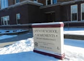 Thumbnail 11 of 11 - A sign for Spencer School Apartments sits in the snow.