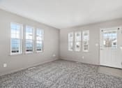 Thumbnail 5 of 25 - A room with a carpeted floor and a door on the right side.