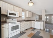 Thumbnail 10 of 25 - A kitchen with white appliances and cabinets.