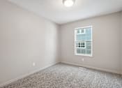 Thumbnail 15 of 25 - A room with a window and carpeted floor.