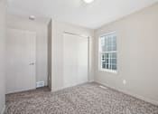 Thumbnail 16 of 25 - A room with a carpeted floor and a window with blinds.