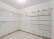 Thumbnail 17 of 25 - Empty room with wire shelving and white walls.