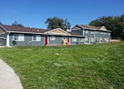 Thumbnail 2 of 7 - A row of houses with a clear blue sky above them.