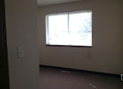 Thumbnail 6 of 7 - A room with a window and a light switch on the wall.