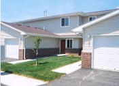 Thumbnail 1 of 13 - A house with a garage and a tree in front.